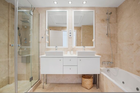 A modern bathroom with a glass-enclosed shower, two sinks, a large mirror, and a bathtub. - Sea View Apartment in Casares del Mar - Ref M50 (Casares)