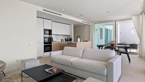 A modern living room with a sofa, a coffee table, and a dining area with a table and chairs. - Hillside Flat With Pool in Palo Alto - Ref M49 (Ojén)