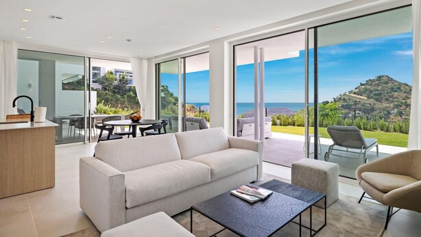 A modern living room with a large sofa, a coffee table, and a view of the sea through large windows. - Hillside Flat With Pool in Palo Alto - Ref M49 (Ojén)