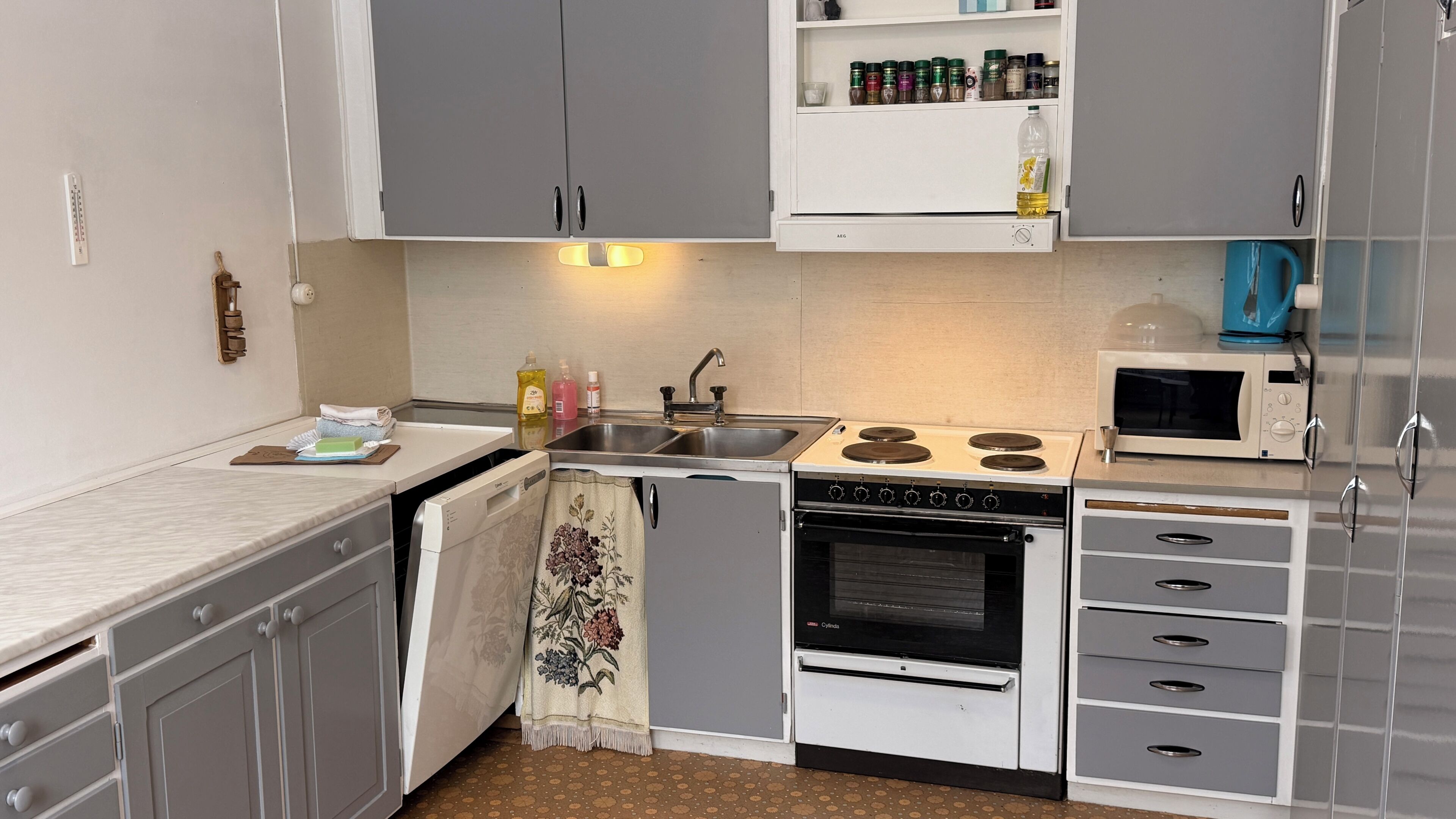 Una cocina compacta equipada con lavavajillas, estufa, horno y microondas.