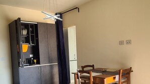 A compact living space with a kitchenette, dining area, and a sofa. - VILLA FIORITA LAKE VIEW APARTMENT (Avigliana)