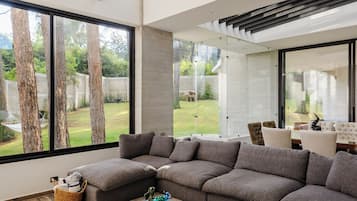 Casa familiar, vista al jardín | Área de sala de estar | Televisión de pantalla plana de 50 pulgadas con canales digitales