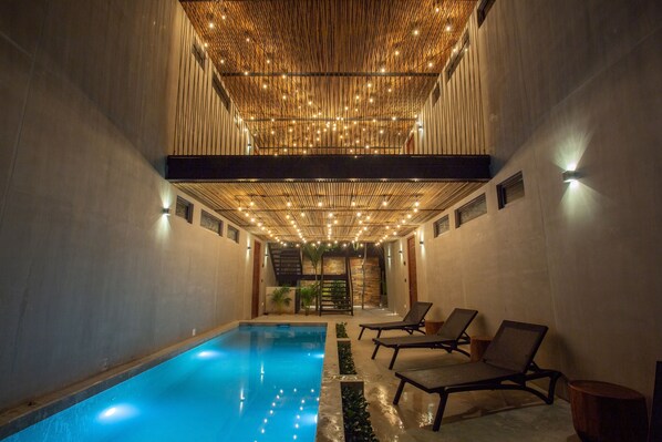 Een buitenzwembad en ligstoelen