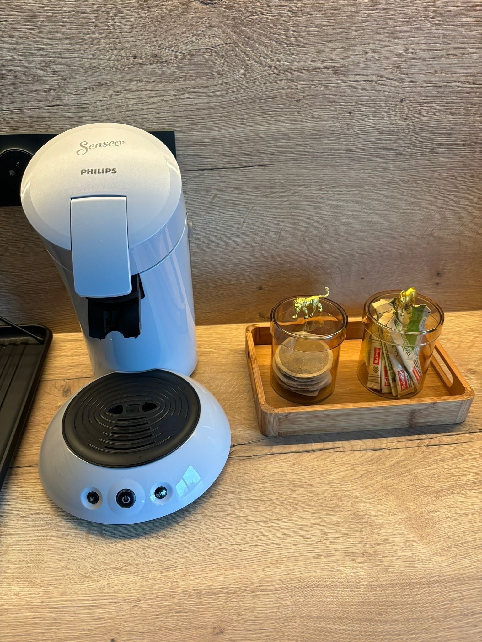 Une machine à café et un petit appareil électrique sur une surface en bois.