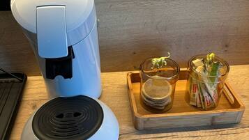 Une machine à café et un petit appareil électrique sur une surface en bois.