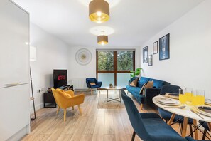 A modern living room with a TV, seating, a dining table, and a large window. - Sleeps 5, 9 Min Drive to Studio Tour, 19 Min Train to London (Hertfordshire)