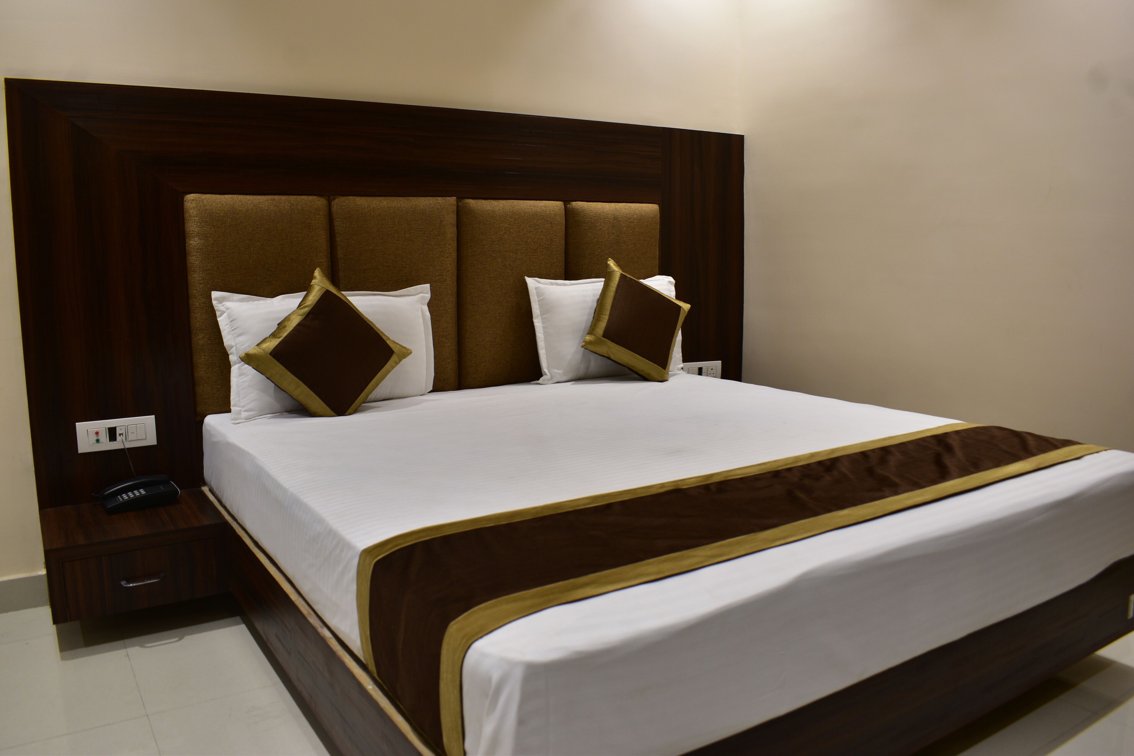 A neatly made bed with a brown headboard and white bedding.