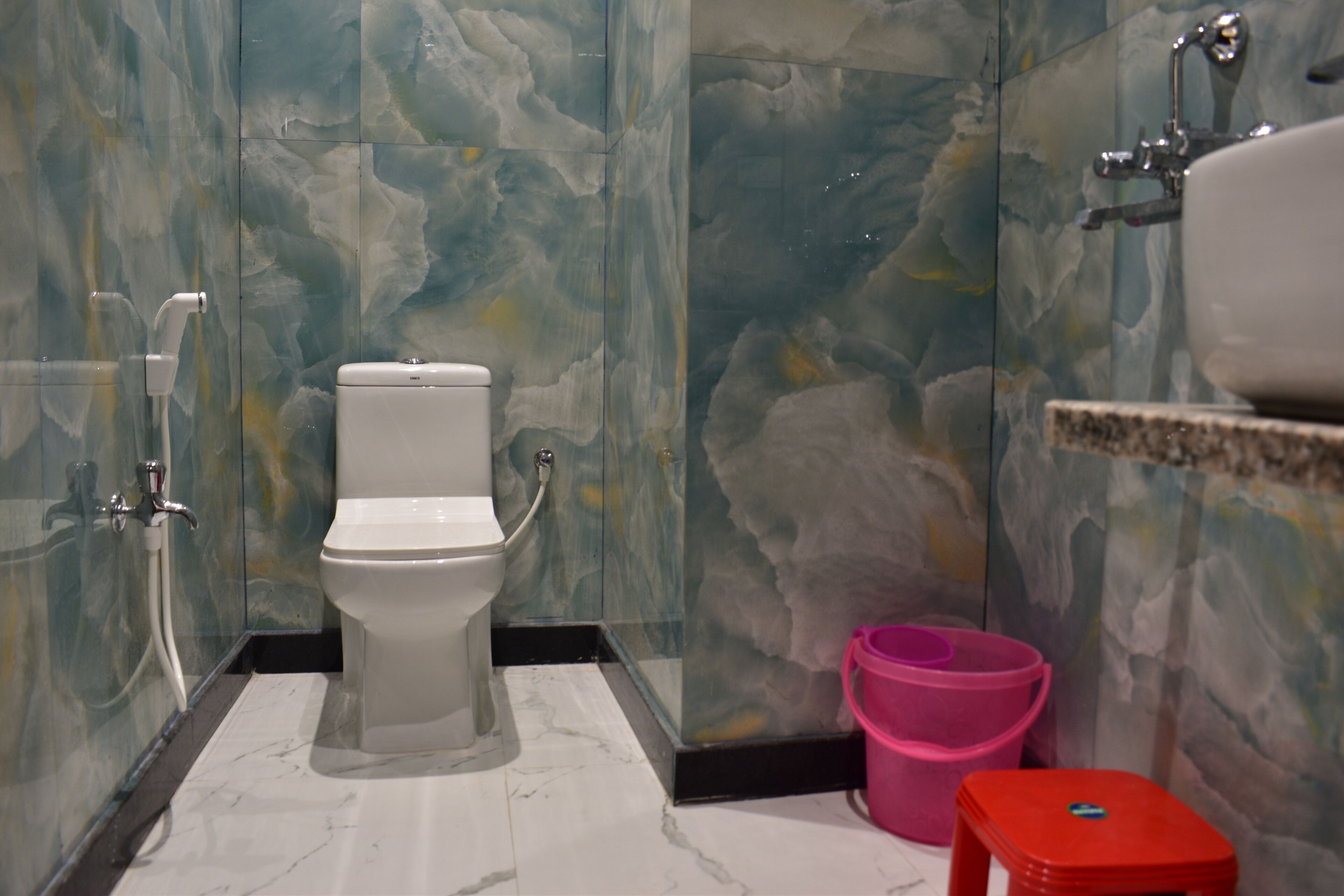 A bathroom with a toilet, a shower, and a sink.