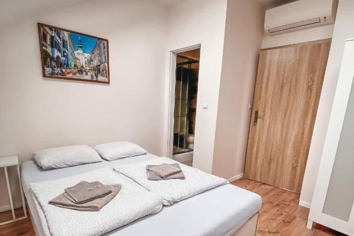 Une chambre à coucher avec un lit, un tableau accroché au mur et une armoire en bois.