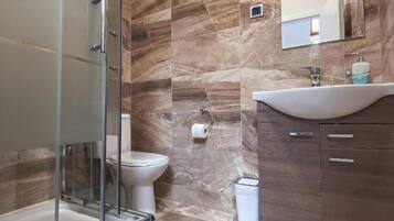 Een douche, een regendouche, handdoeken, toiletpapier