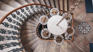 En spiraltrappe med en central søjle, omkranset af et dekorativt gelænder.