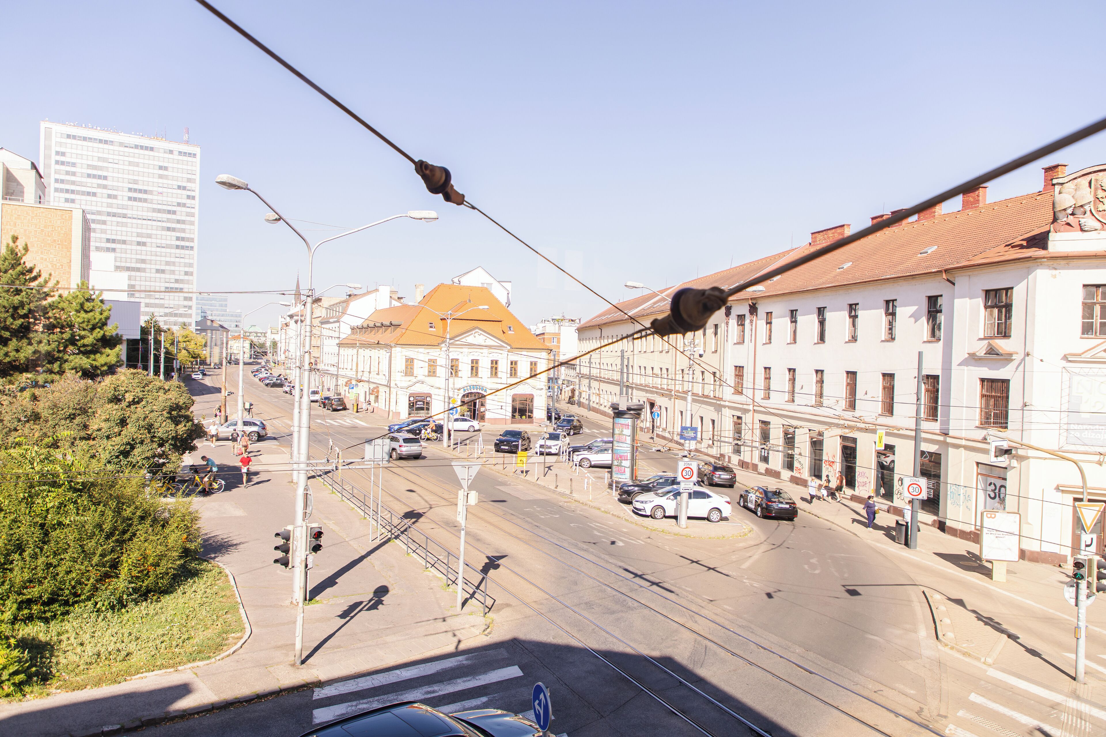 Vista de una calle con edificios, automóviles y una línea de tranvía.