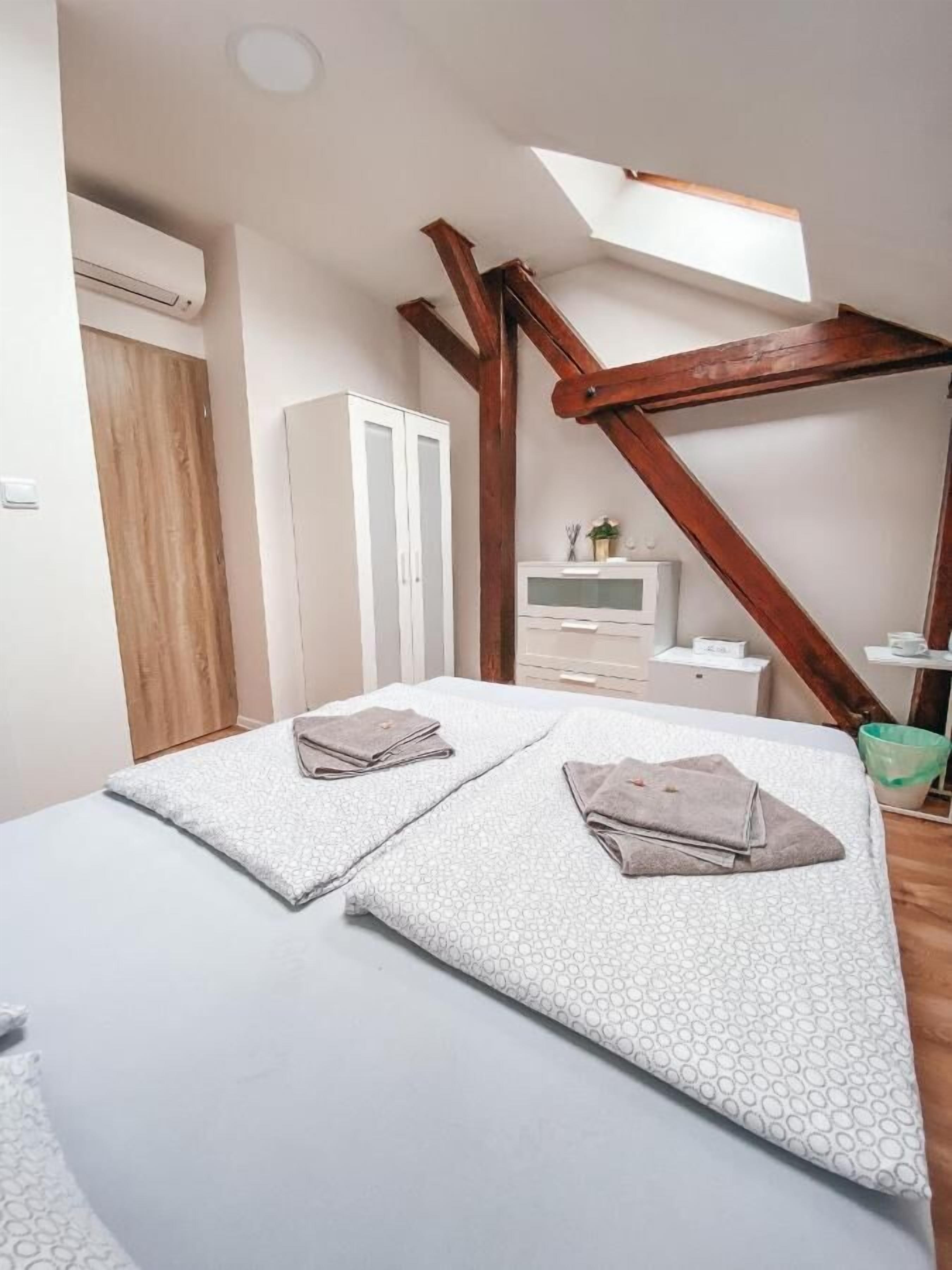 Un dormitorio con cama, armario, escritorio, silla y ventana.