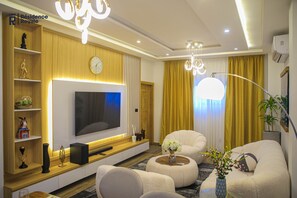 A modern living room with a flat-screen TV, comfortable seating, and decorative elements.