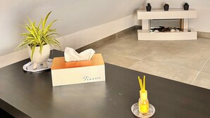 A modern living room with a black countertop, a white tissue box, a potted plant, and a small decorative item.