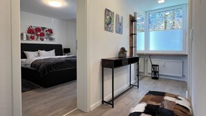 A modern bedroom with a bed, bedside table, and artwork on the wall. - Your perfect getaway for a relaxing vacation, including Unlimited Mountain Rail Pass (Oberstdorf)