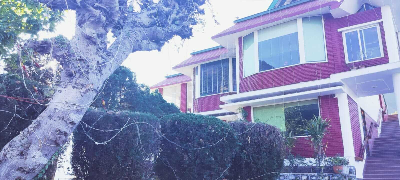 Une maison à deux étages avec une façade en briques rouges et des éléments décoratifs blancs.