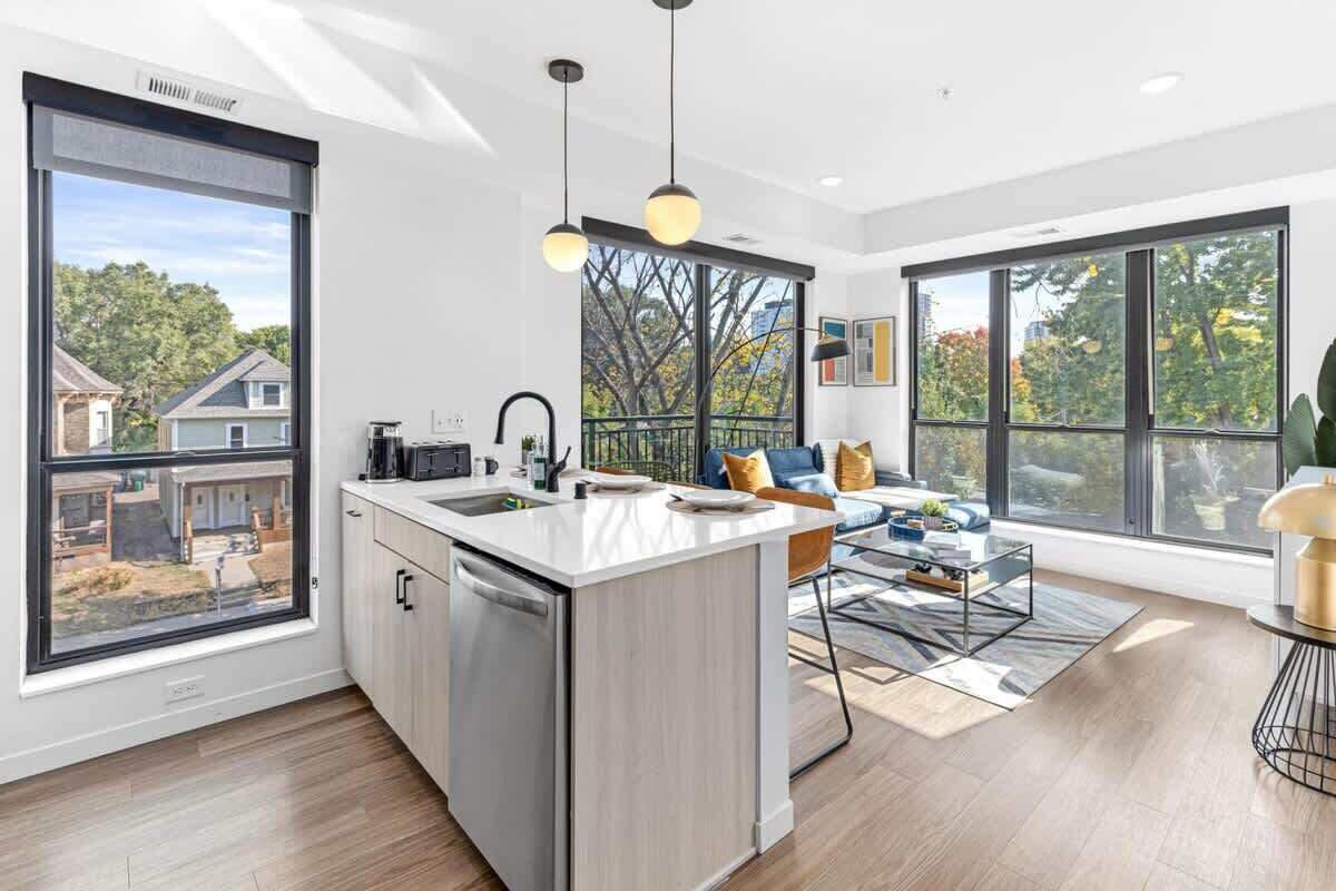 Bright, open layout with modern kitchen, cozy living area, and floor-to-ceiling windows.