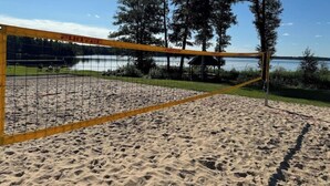 Una cancha de voleibol de playa con arena y una red que dice 'FUNTEC'.