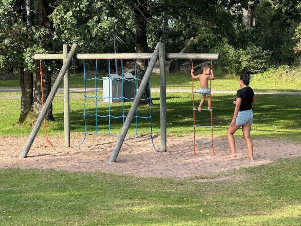 A playground with a wooden climbing structure and a sandpit.