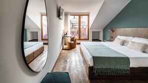 A bedroom with a large mirror, a bed with a green throw, wooden flooring, and a view of the outside balcony. - Suite in Colonne San Lorenzo Milano (Milan)