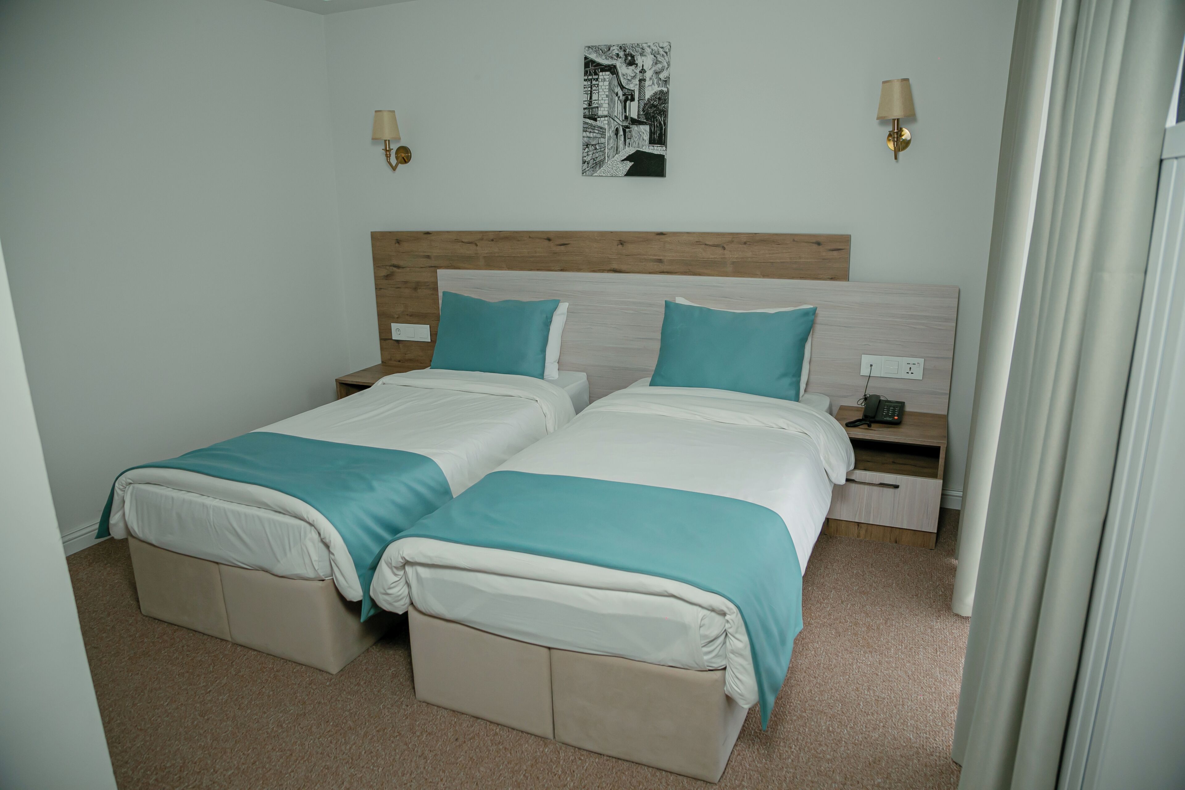 A double bed with a wooden headboard, two bedside tables, and a wall-mounted lamp.