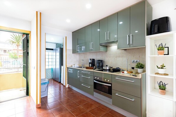 A modern kitchen with green cabinets, a built-in oven, and a coffee maker. - Aquarius 18 by VillaGranCanaria (San Bartolomé de Tirajana)
