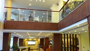 A multi-level hotel lobby with a wooden interior, glass railings, and a seating area. - Holiday Hotel Addis Ababa (Addis Ababa)