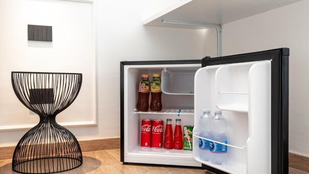 Una cocina moderna con refrigerador empotrado que contiene bebidas y aperitivos.