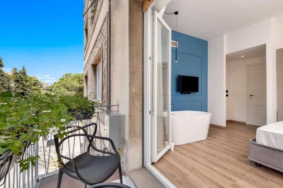 Ein modernes Apartment mit Balkon, großem Fenster und einer integrierten Badewanne.