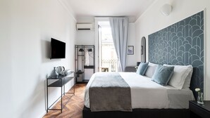 Habitación de hotel moderna con una cama grande, televisión, armario y vistas a la ciudad.