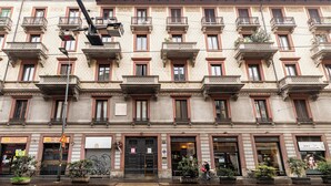 Un edificio de varios pisos con una fachada simétrica, con ventanas y balcones distribuidos uniformemente.