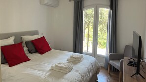 Une chambre d’hôtel avec un lit, une télévision et une fenêtre avec des rideaux.
