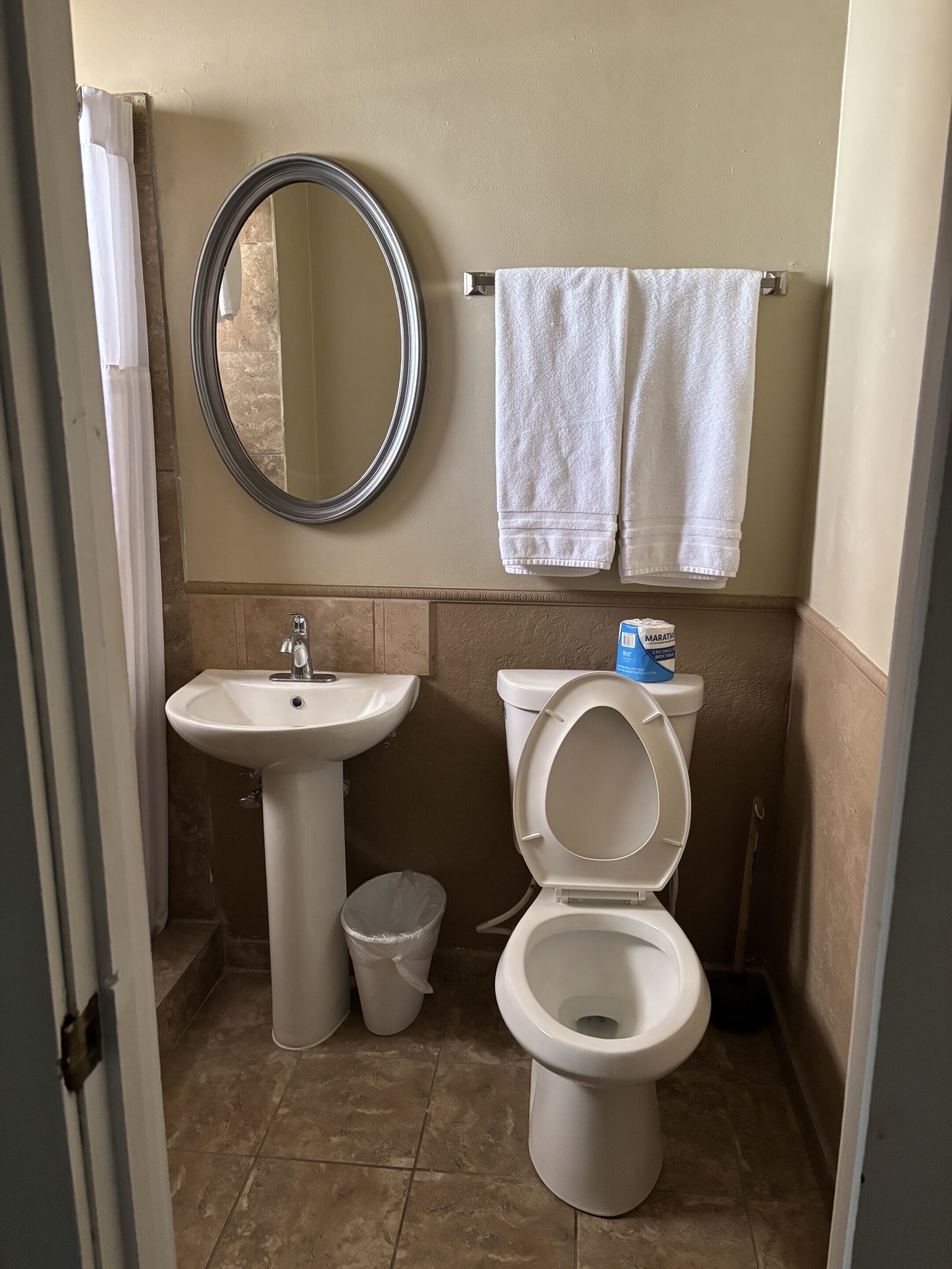 Een badkamer met een wastafel, toilet en spiegel.