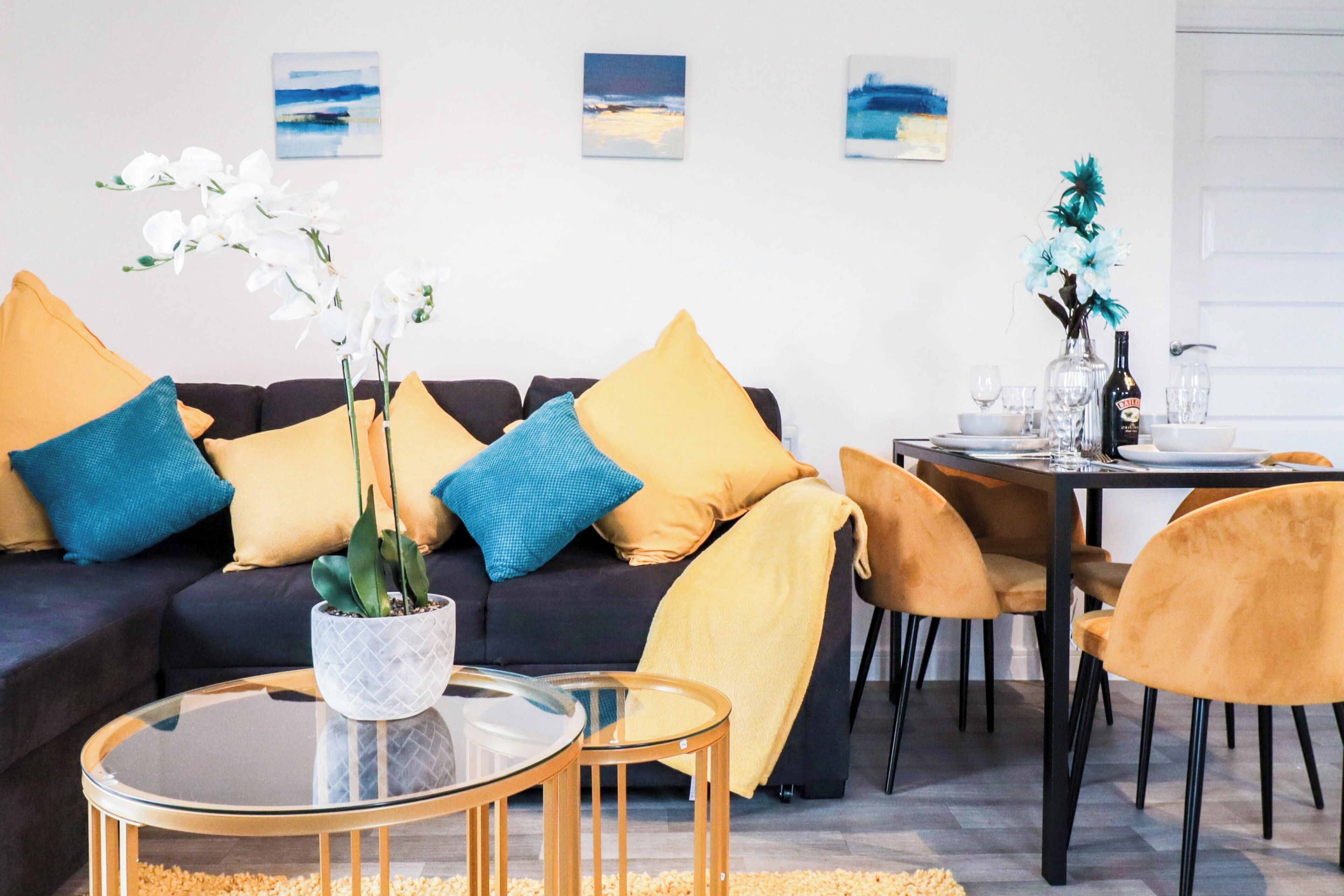 A modern living room with a sofa, coffee table, and dining area.