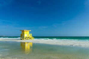 A lifeguard tower on a beach with clear blue sky and calm sea. - Saltwater Siesta Sarasota Private Home with Resort Style Backyard and Heated Pool, Mini Golf, Fire Pit, Game Room with Arcade, Near IMG, not far from beaches. 4BR/3BA, sleeps 10. (Sarasota)