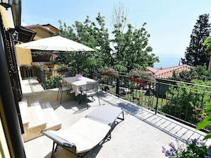 A balcony with a table and chairs, a sun lounger, and a view of the sea. - Charming Holiday Home With Terrace and Garden - One Bedroom Holiday Home (Moscenicka Draga)