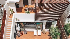 A modern, multi-level residential space with a dining area, seating, and a balcony with plants. - Luxury Villa-4BDR Private Pool & Jacuzzi (Tulum)