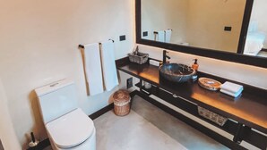 A modern bathroom with a toilet, a sink with a large mirror, and a towel rack. - Luxury Villa-4BDR Private Pool & Jacuzzi (Tulum)