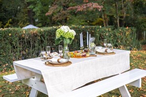 An outdoor dining table set with food, drinks, and candles. - Modern Villa w Pool, Hot Tub & Games! (Greensboro)