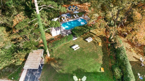 Vue aérienne d’une cour arrière avec une piscine, une terrasse et un petit abri de jardin.