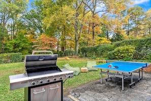 An outdoor area with a grill and a ping pong table. - Modern Villa w Pool, Hot Tub & Games! (Greensboro)