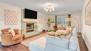 A living room with a fireplace, sofa, and television.