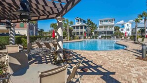 A pool area with lounge chairs and a pergola. - One Bedroom, 620 Sq Ft, Seacrest Beach, Free Bikes (Panama City Beach)