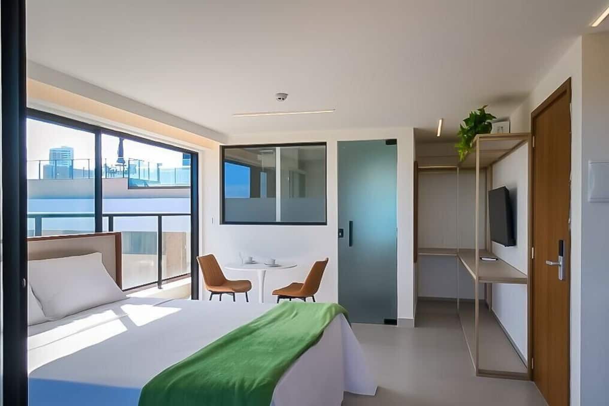 Une chambre d’hôtel moderne équipée d’un grand lit, d’un bureau, d’une chaise et d’un téléviseur.