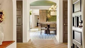 A hallway leading to a dining area with a tiled floor and a chandelier. - Villa Encanto- Luxe 6BRs • Courtyard • Game Room (Long Beach)