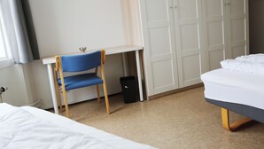 A bedroom with a bed, a desk with a chair, and a wardrobe. - Hostel Oslofjord (Bærum)