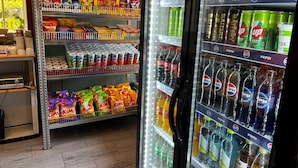A vending machine stocked with snacks and beverages, including chips, sodas, and energy drinks. - Hostel Oslofjord (Bærum)