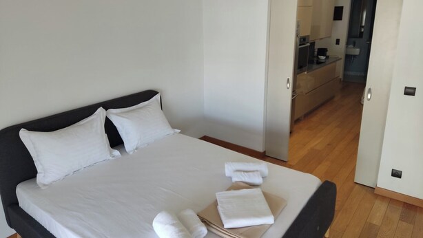 A hotel room with a large bed, white linens, and neatly folded towels on the bed. - Luxury Living Athens  (Athens)
