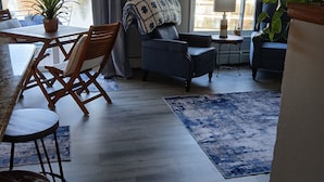 A living room with a dining area, a large mirror, and a view of a body of water.